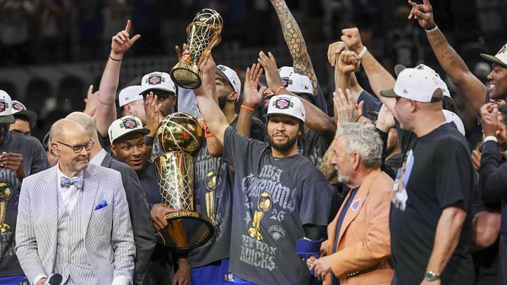 Jalen Brunson raises the Finals MVP trophy alongside his Knicks teammates and the Larry O’Brien championship trophy after Game 5.